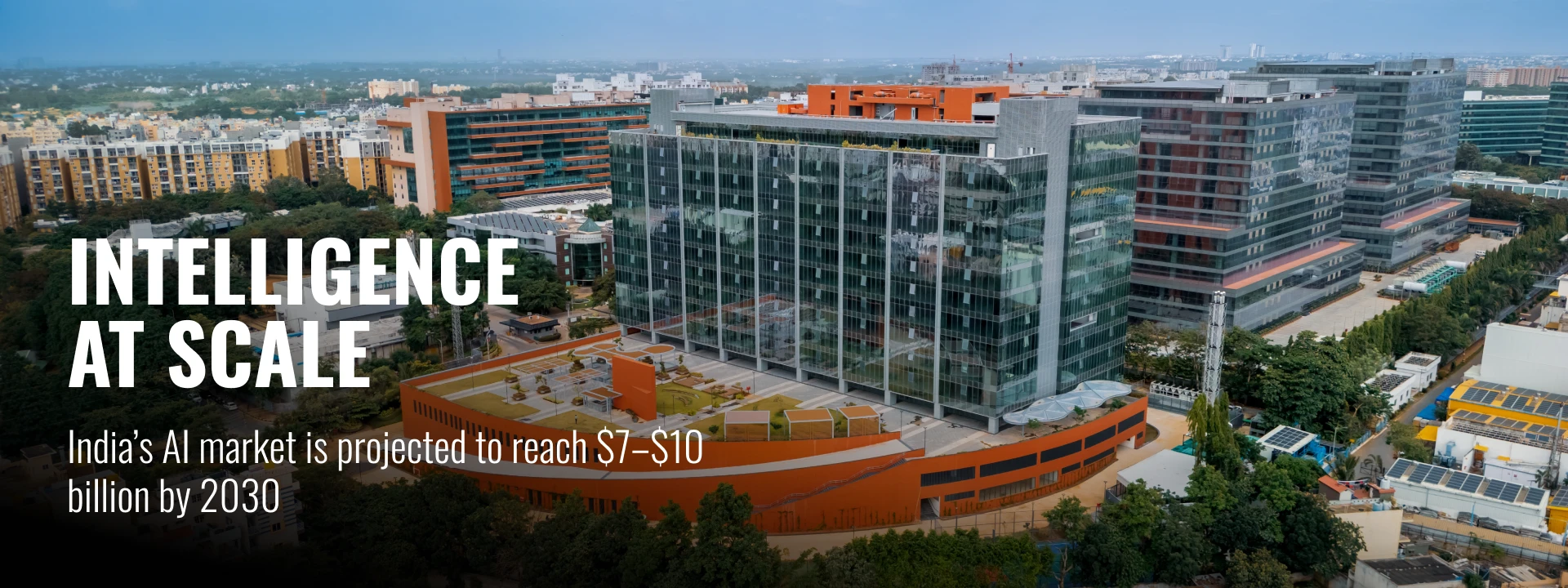 Aerial view of a tech campus with text about India’s AI market growth by 2030.